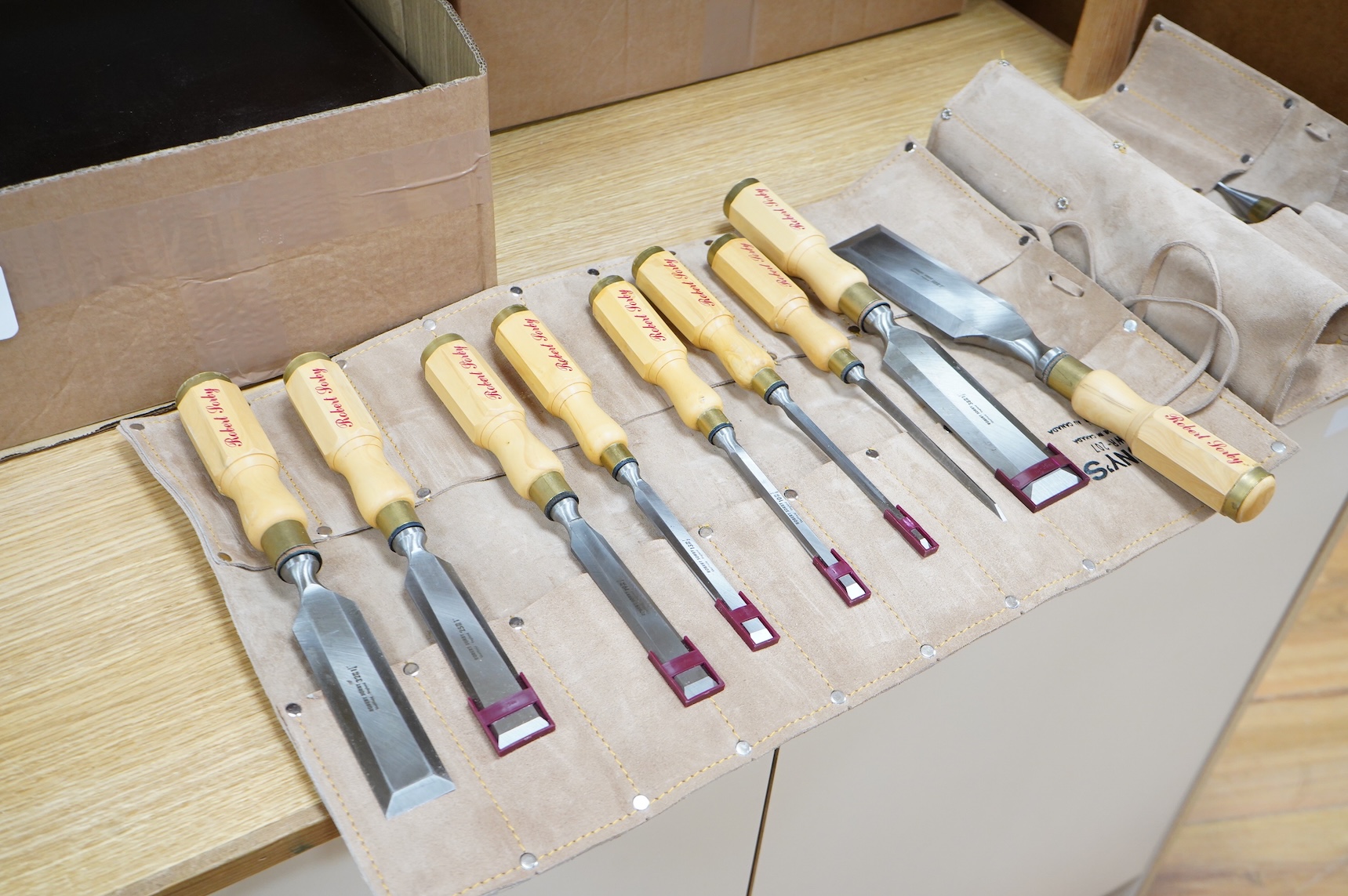 Two sets of Robert Sorby woodworking chisels, both in Kuny’s of Canada leather tool rolls; a nine piece set with octagonal handles, together with a six piece set with rosewood handles
